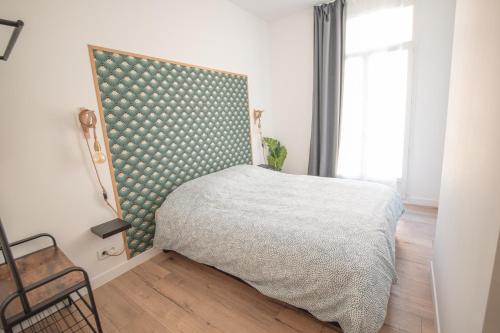 - une chambre avec un lit doté d'une tête de lit verte et blanche dans l'établissement Le comptoir des grenouilles, à Marseille