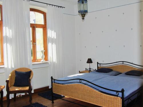 a bedroom with a bed and a chair at Gästehaus EinsA in Celle