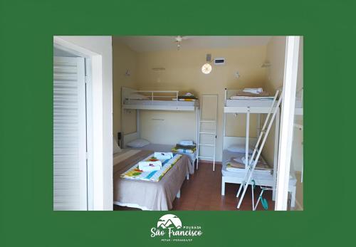 um pequeno quarto com uma cama e beliches em Pousada São Francisco PETAR em Iporanga