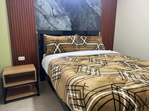 um quarto com uma cama com um quadro na parede em Hotel Colonial House em Pasto