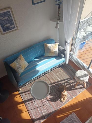 un canapé bleu dans un salon avec une table dans l'établissement Bandol - 