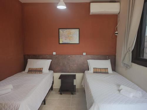 um quarto com duas camas e uma mesa em Pousada Guesthouse em Timbó