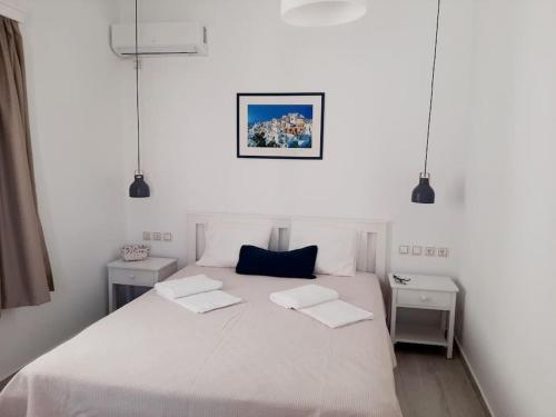 una camera bianca con un grande letto bianco con due comodini di Bright town house a Kampos Paros
