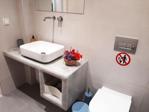 un bagno bianco con lavandino e WC di Bright town house a Kampos Paros
