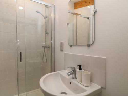 uma casa de banho branca com um lavatório e um chuveiro em The Cook House em Devizes