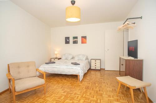 um quarto com uma cama e uma cadeira em Modern 3-bedroom apartment in city centre em Basileia