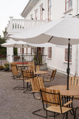 a row of tables and chairs with an umbrella at Ulvsby Herrgård in Sunne
