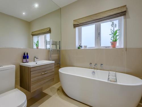 a bathroom with a tub and a toilet and a sink at 4 Bed in Llandudno 80288 in Rhôs-on-Sea