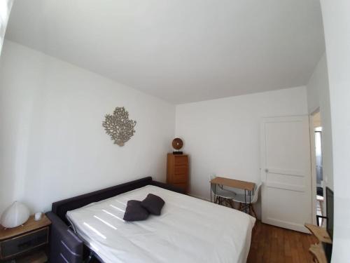 um quarto branco com uma cama e uma mesa em Chambre privée dans magnifique appartement calme em Paris