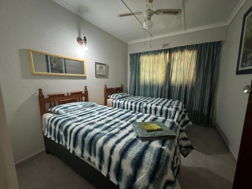 Un dormitorio con dos camas y una ventana. en Apt 26 Eden Wilds Umtamvuna Getaway, en Port Edward