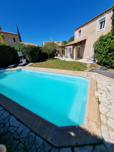 une piscine bleue devant une maison dans l'établissement Villa avec Piscine, sans vis-à-vis, plage à 13mn à pieds, à La Seyne-sur-Mer
