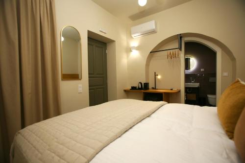 a bedroom with a white bed and a mirror at Living Yard Acropolis in Athens