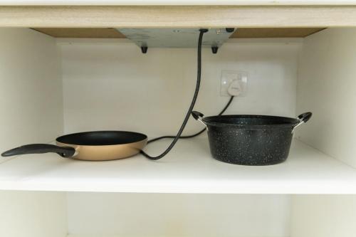 a pot and a pan sitting on a shelf at CoreSoho Suite by BKAstaycation KotaWarisan Sepang KLIA Airport, Free Wifi in Sepang