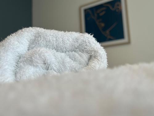 a white towel laying on top of a bed at Central Darlington Large Penthouse Apartment in Darlington