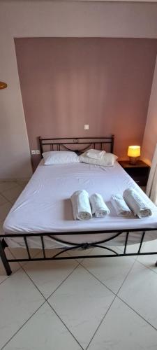 a bed with white sheets and pillows on it at ΔΙΑΜΕΡΙΣΜΑ ΚΕΝΤΡΟ ΑΝΤΙΚΥΡΑΣ in Antikyra