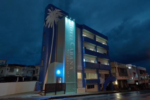 a building with a palm tree on the side of it at Hotel CABANA カバナ 宮古島 in Miyako Island