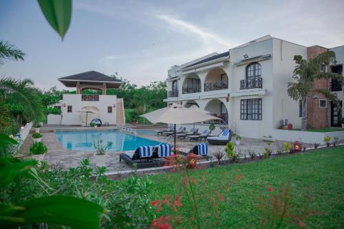 a large white house with a swimming pool at Mzima Beach Residences - Diani Beach in Diani Beach