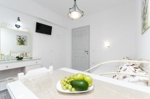a white kitchen with a plate of fruit on a table at Naxos Dream Aphrodite Studios in Naxos Chora