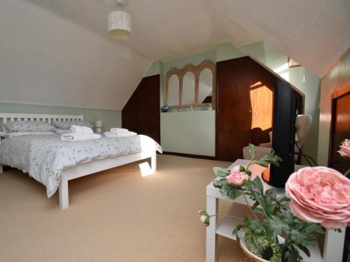 a bedroom with a bed and a tv and flowers at 2 Bed in Winfrith Newburgh DC018 in Winfrith Newburgh