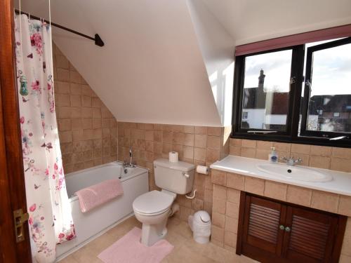 a bathroom with a toilet and a tub and a sink at 2 Bed in Winfrith Newburgh DC018 in Winfrith Newburgh