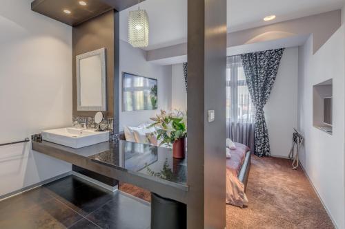 uma casa de banho com um lavatório e um espelho em Starlight Luxury Rooms em Split