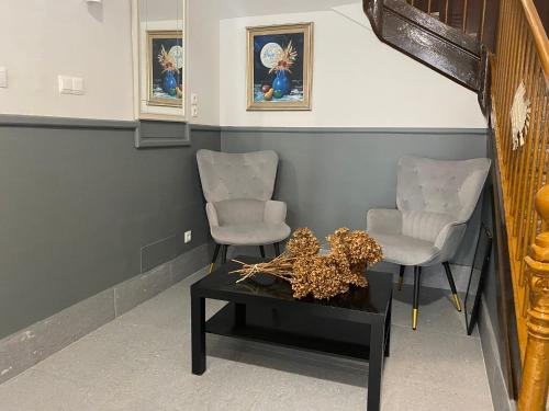 a living room with two chairs and a table at Hostal Restaurante La pinta in Ampuero