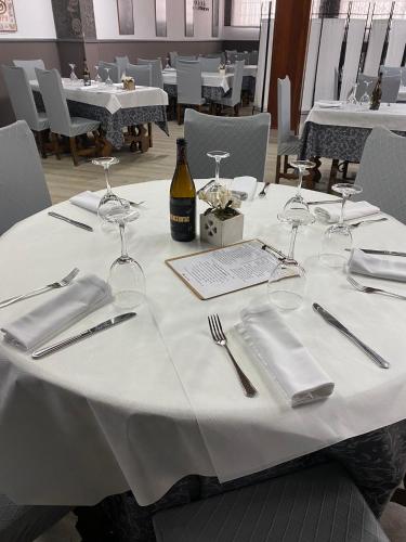 a table with glasses and a bottle of wine on it at Hostal Restaurante La pinta in Ampuero