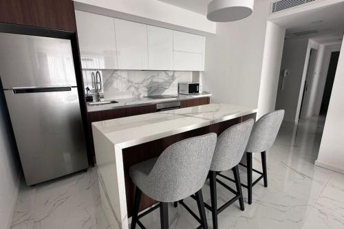 a kitchen with a counter with chairs and a refrigerator at 2 Bedroom Amazing sea view Grand Sapphire in Iskele