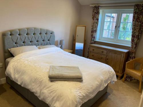 a bedroom with a large bed and a window at Hen House: Private annexe on stunning farm in Melton Mowbray