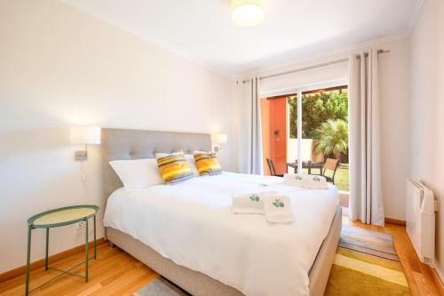 a bedroom with a large white bed with yellow pillows at Casa do Jardim- Aroeira in Aroeira