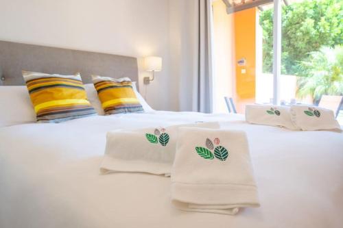 1 dormitorio con 2 camas blancas y toallas. en Casa do Jardim- Aroeira en Aroeira