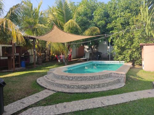 a swimming pool in a yard with a hammock above it at Beach Lomas in La Libertad