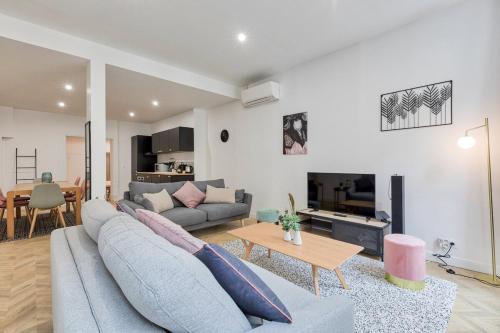 ein Wohnzimmer mit einem Sofa und einem Tisch in der Unterkunft Appartement luxueux proche Arc-de-Triomphe - 4P in Paris