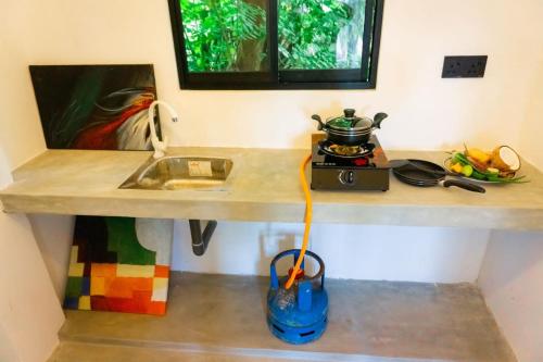 un comptoir de cuisine avec un évier et une cuillère dans l'établissement Mountain Relax Inn, à Weligama