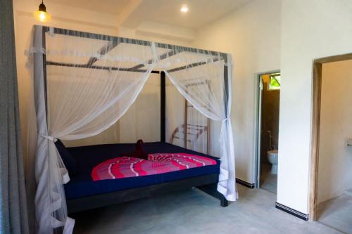 a bedroom with a bed with a canopy at Mountain Relax Inn in Weligama
