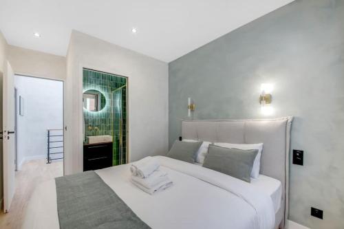 a bedroom with a large white bed with a mirror at Luxueuse maisonnette au coeur de Batignolles 17eme in Paris