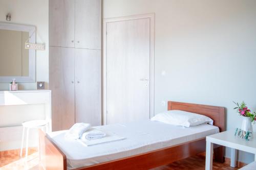 ネア・ポティダイアにあるVilla Oramaの白いベッドルーム(ベッド1台、鏡付)