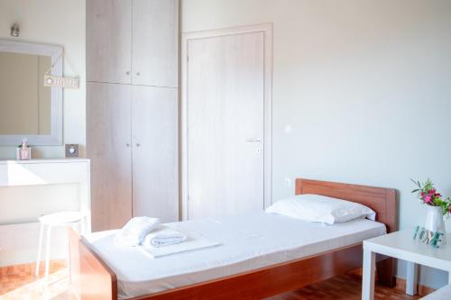 a white bedroom with a bed and a mirror at Villa Orama in Nea Potidaea