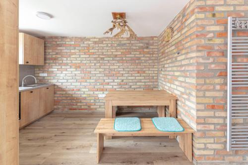 a kitchen with a brick wall and a wooden table at Apartma Naravni biser in Brezje