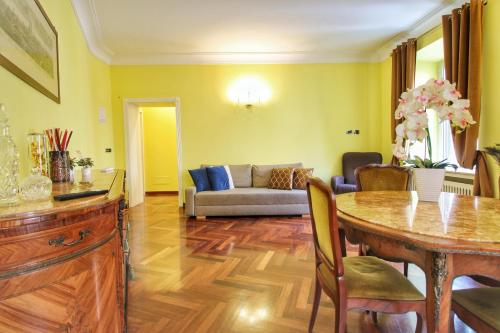 罗马Large and Charming Apartment in Trastevere by YourHost的客厅里有一张桌子和一张沙发