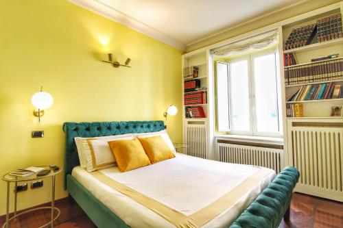 een slaapkamer met een bed met gele muren en een raam bij Large and Charming Apartment in Trastevere by YourHost in Rome