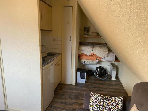 Cette petite chambre dispose d'une cuisine et d'un escalier avec un lit. dans l'établissement Studio cosy pour 3 pers, 200m des pistes, Le Pleynet - FR-1-557A-51, à La Ferrière