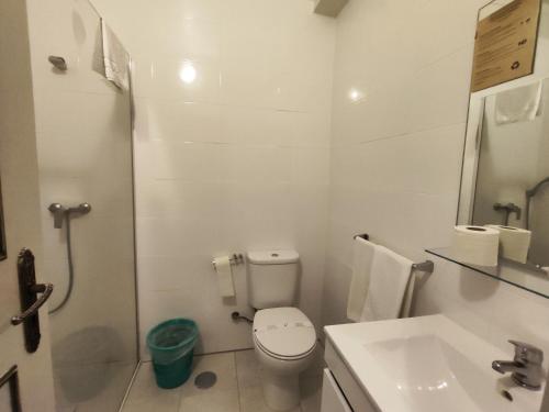 a white bathroom with a toilet and a sink at Residencial Centro Comercial Avenida Bragashopping in Braga