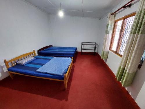 a bedroom with two beds and a red carpet at Carmalin Holiday Bungalow in Nuwara Eliya