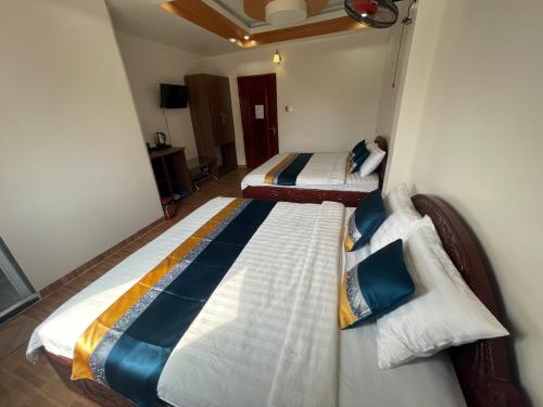 two twin beds in a room with at Trung Hiếu Hotel - bên cạnh Miếu Bà Chúa Xứ in Chau Doc
