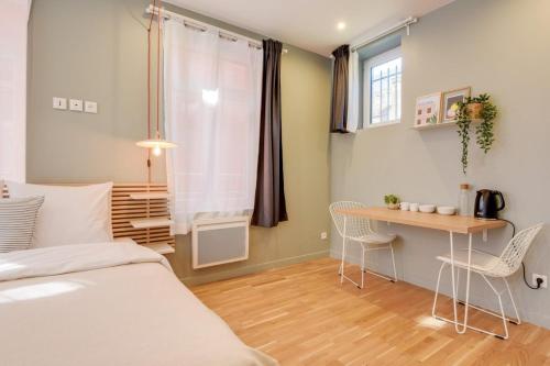 une chambre avec un lit, un bureau et une table dans l'établissement Lille train station: equipped studio, à Lille