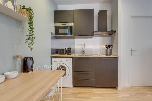 une cuisine avec un évier et un lave-vaisselle dans l'établissement Lille train station: equipped studio, à Lille