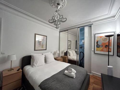 Un dormitorio con una cama blanca con un pato blanco. en Cosy Flat 2 BDR Arc de Triomphe Champs Elysées, en París