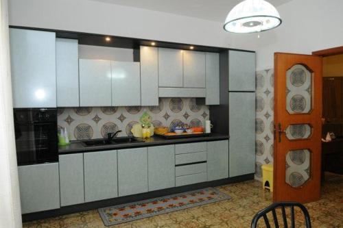 a kitchen with white cabinets and a sink at I Messapi in Mesagne