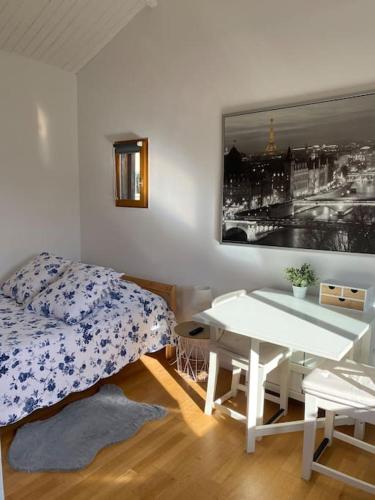 een slaapkamer met een bed en een tafel en een foto bij Le Chalet Pignantais in Pignans